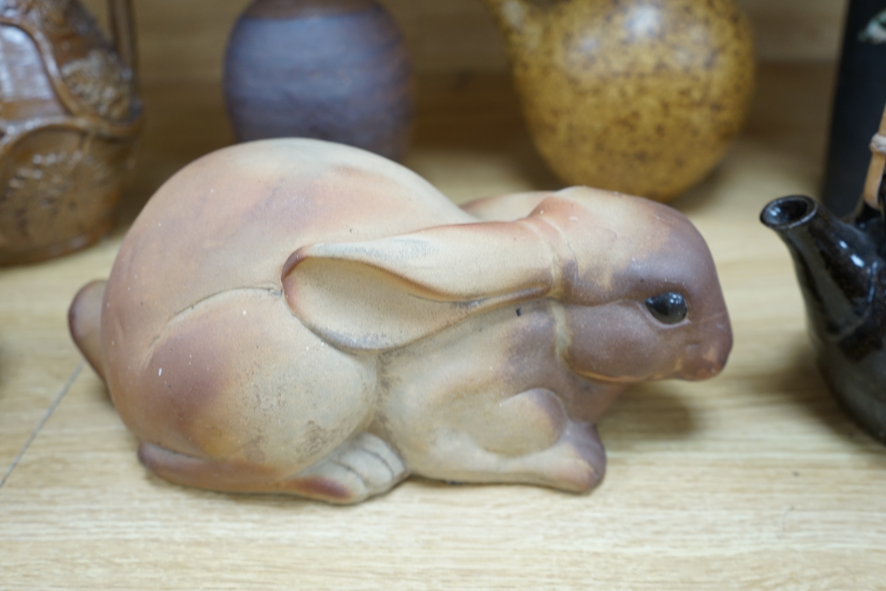 A collection of Studio pottery to include teapots and jugs, together with a pottery model of a rabbit, indistinctly signed to the base, and a French salt glazed wine jug, largest 33cm high. Condition - fair to good